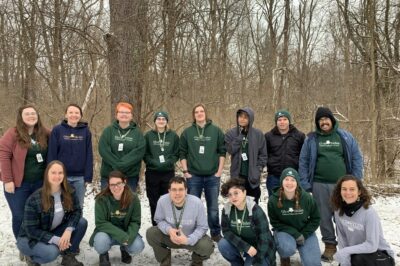 A group photo of all naturalists, including Rosabella, outside in the snow.