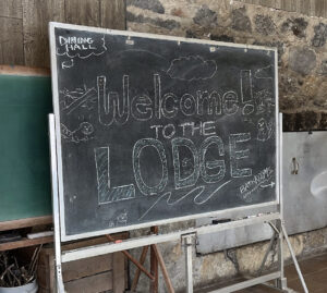 A chalkboard with cartoon beavers that says "Welcome to the Lodge!"